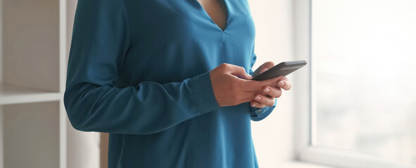 Mobile texting. Gadget communication. Digital leisure. Woman hands with modern smartphone device typing chat message on social media in light interior.