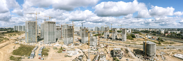 Obraz premium big construction site with apartment buildings under construction. panoramic aerial view in sunny summer day.