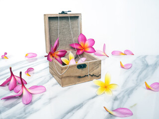 Piece of white marble with colorful flowers in a wooden box