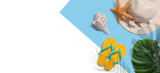 Summer concept with a straw hat, starfish, beach sandals and shell overhead view