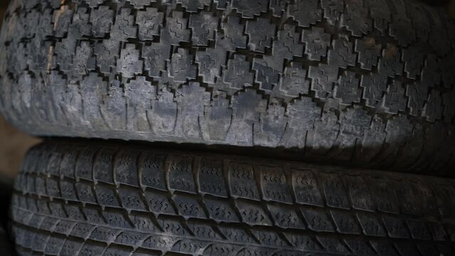 Two old car tires with different tire patterns. The difference between hard and road tires
