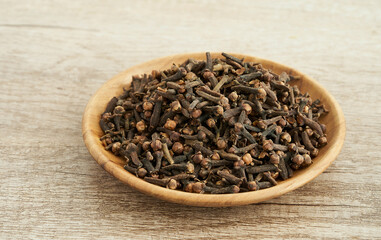 dry clove spice in wood bowl on table background. dry clove spice background. pile of dry clove spice in wood bowl food table background                             