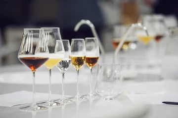 Fotobehang Various alcoholic beverages in glasses in white table in wine room. Sommelier school, professional certification, winemaking association. © Ilshat