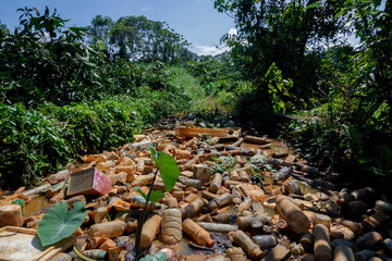 Piles of waste left over from plastic beverage bottles in ditches which cause water to clog and not...