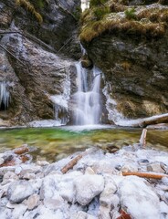 Beautiful winter hiking trail in gorge of Slovak Paradise NP. Metal climbing ladder with icefall and wild stream. Wilderness in Slovensky raj National Park, Slovakia - obrazy, fototapety, plakaty