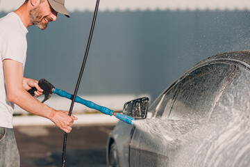 Worker washing car at self-service car wash