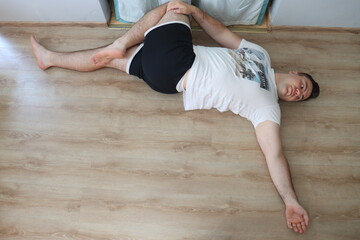 A young man does an exercise to strengthen the muscles of the back at home