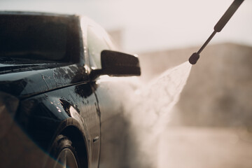 Worker washing car at self-service car wash - 619317341