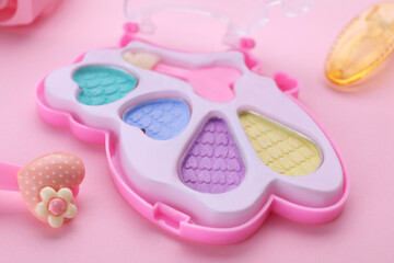 Decorative cosmetics for kids. Eye shadow palette on pink background, closeup