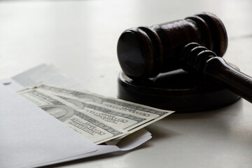 Dollars in an envelope and judge's gavel on the table, corruption and bribery