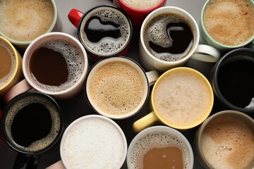Many different cups with aromatic coffee on grey table, flat lay