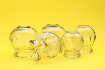 Glass cups on yellow background. Cupping therapy