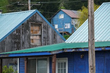 Street city view with wooden houses, shops, cars and mountain wilderness nature in Hoonah, Icy Strait Point in Alaska, popular cruise destination for whale watching in wildlife tours