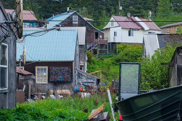 Street city view with wooden houses, shops, cars and mountain wilderness nature in Hoonah, Icy...