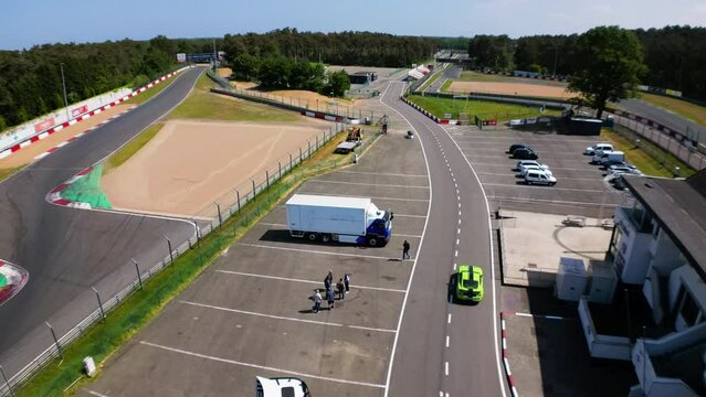 Logistic transport parked near race circuit, aerial drone view