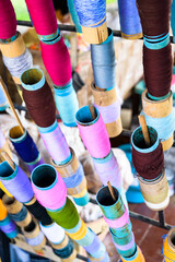 Multi coloured yarn spools are prepared for Lanna style traditional umbrella making