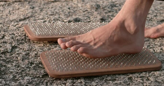 bare feet of yogi male preparing to stand on the sadhu boards with sharp nails mental strength practice mental strength male standing on nails meditation healthy body and mind mental strength concept