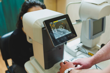 Examination of vision on modern ophthalmological equipment. Eye examination of a woman at an...