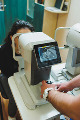 Examination of vision on modern ophthalmological equipment. Eye examination of a woman at an...