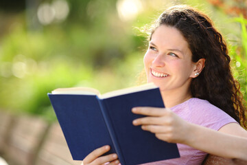 Happy book reader dreaming in a park