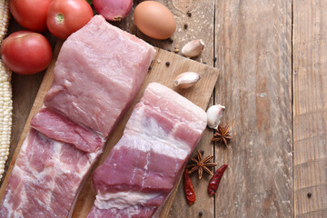 Fresh raw pork on a cutting board with vegetables