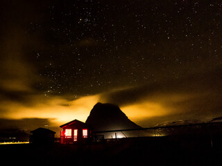 Illuminated Cottage with Volcano: Stars and Clouds in Iceland