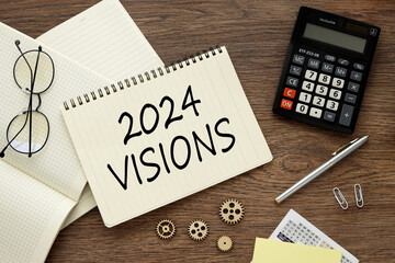 2024 visions top view on notebook stickers calculator and paper clips.text on page