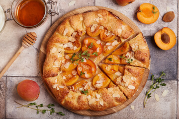 Galette with apricots, brown sugar, honey, and almond petals. Delicious homemade open sweet pie...