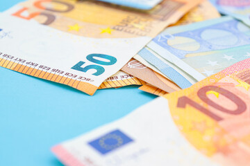 10, 20 and 50 euro bills on a blue background with copy space