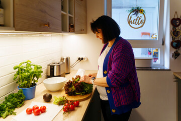 Pregnant woman with vegetables preparing food at home