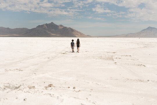 boy and girl wlaking on salt flats of Utah at Bonneville