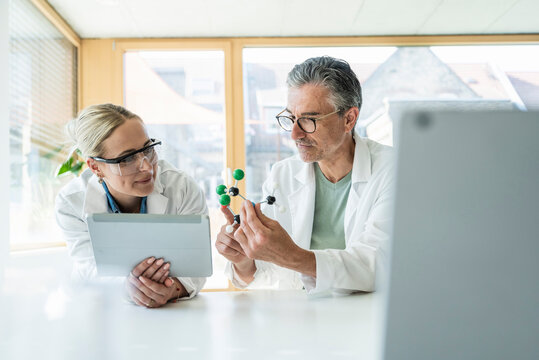 Scientists researching on molecule structure with tablet PC in laboratory