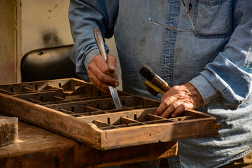  Man holding tools and carving into wood 