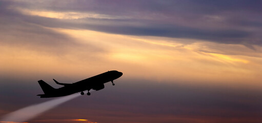 Fototapeta na wymiar The plane takes off at sunset.