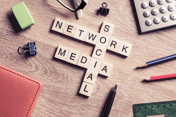Conceptual media keywords on table with elements of game making crossword