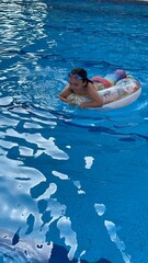 una serena pequeña sobre un flotador en la piscina 