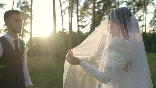Meeting of the bride and groom in the forest at sunset. The first meeting of the bride and groom. Traditions at weddings when the bride bows to the groom. The bride bows when meeting the groom.