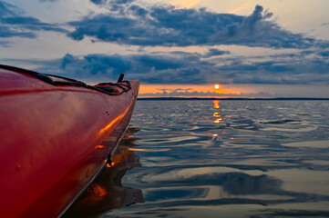 Red kayak in orange sunset over lake Vattern Motala Sweden