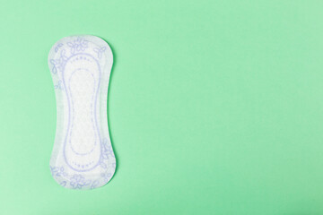 Panty liner on pastel green background. Womens hygiene