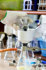 Laboratory glassware with green liquid in a science research laboratory.