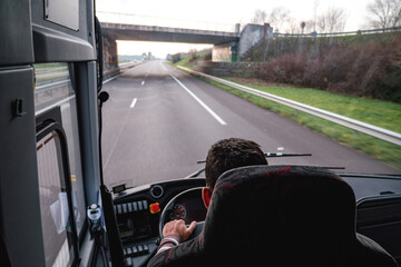 A lone driver commutes on the German autobahn in a coach bus as an overhead view shows the motorway...