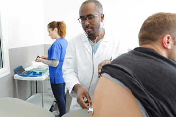 Obraz premium doctor with stethoscope listening to the patient