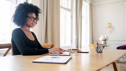 Curly-haired smart making a career in the office. Online education A female student uses a laptop...
