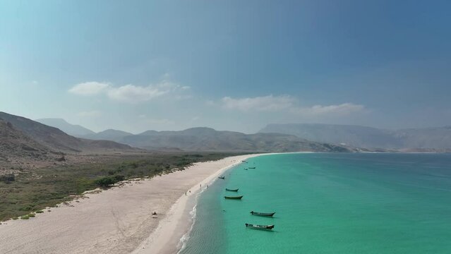 Astounding View Of White Sand And Azure Water Of Shoab Beach With Mountains In Background At Socotra Island In Yemen. aerial, wide shot