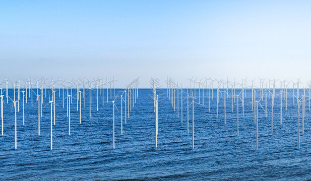 Renewable energy concept with wind mill farm against blue sky