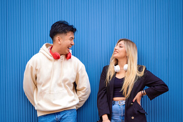 Multi-ethnic friends with headphones looking at each other and smiling. Friendship and technology...
