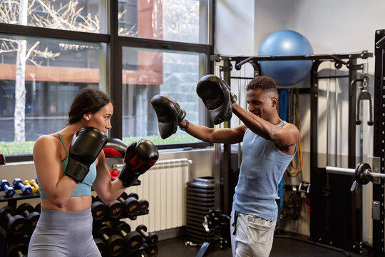 Intense Boxing Workout: African-American Man and Caucasian Woman Wearing Gloves in Gym