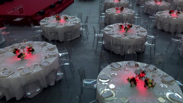 Cinematic image, scenery and flowers at a gala dinner. Luxurious wedding. Banquet arrangement. Table server. Round table. Drone footage. Party Hall