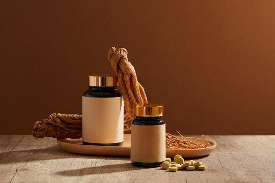 Two unlabeled glass jars decorated with a wooden tray of Angelica root and a pile of yellow medicine. Angelica root (Angelica sinensis) supplement can kill brain cancer in humans