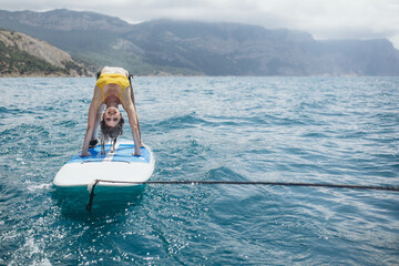 A woman practices yoga on the water. Glanders. - obrazy, fototapety, plakaty
